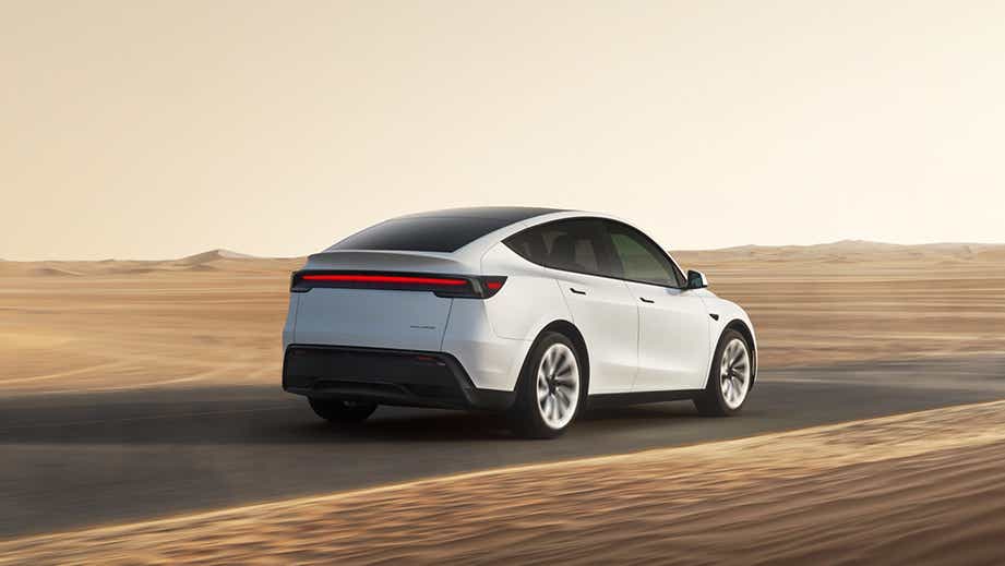 rear three-quarter view of a Pearl White Multi-Coat Tesla Model Y