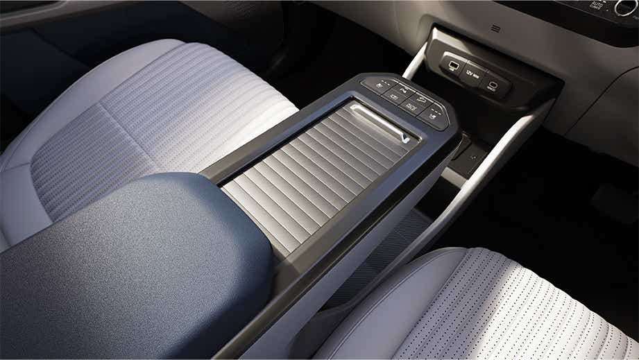 Center console and front seats of a Kia Carens Clavis EV interior
