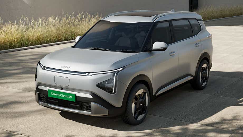 front three-quarter view of a Ivory Silver Matte Kia Carens Clavis EV