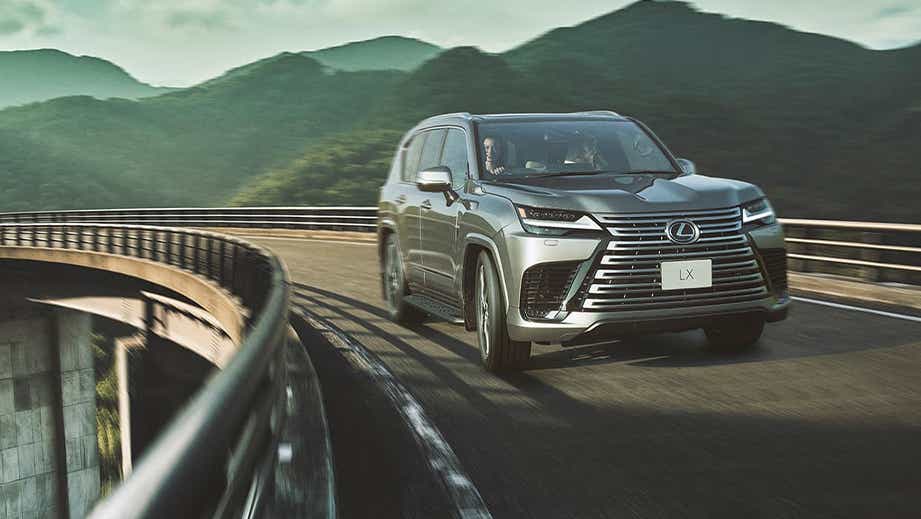 front three-quarter view of a Lexus LX on a winding mountain road
