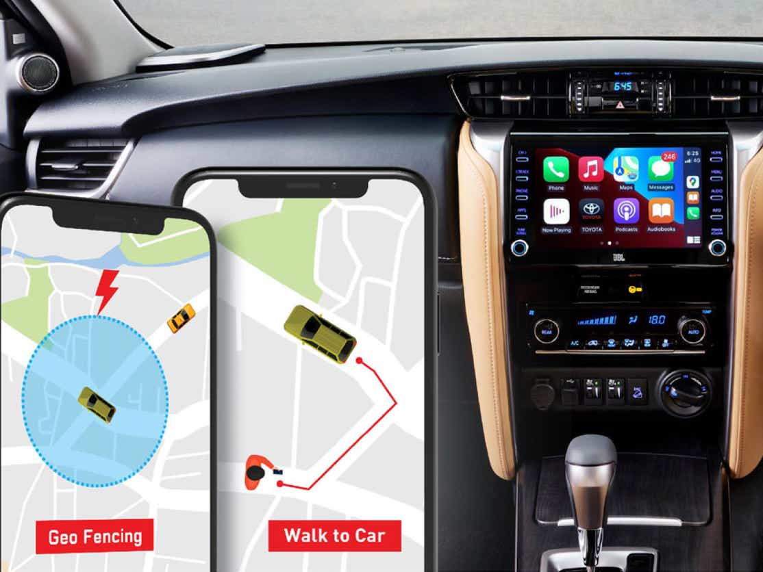 interior dashboard of a Toyota Fortuner facelift with infotainment system and smartphones showing geo-fencing features