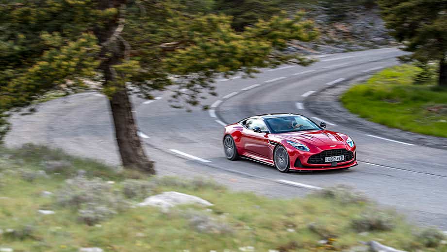 front three-quarter view of an Aston Martin DB12 driving on a winding road