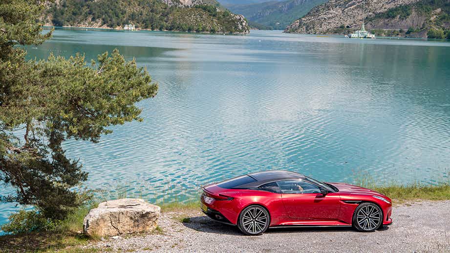 side view of a Aston Martin DB12 coupe by a lake