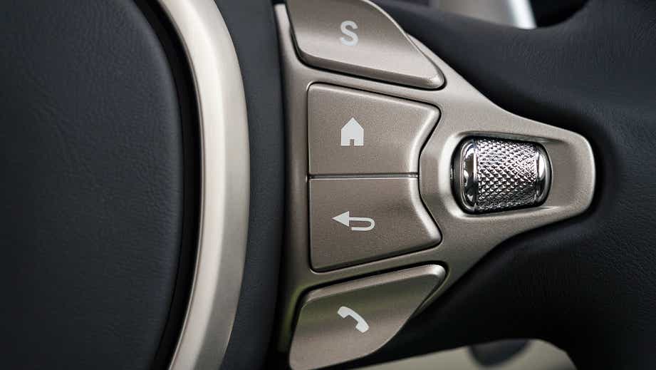 Steering wheel control close-up of a Tiffany Green Aston Martin DB11