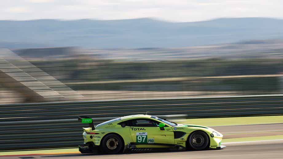 side view of a Sunburst Yellow Aston Martin Vantage race car