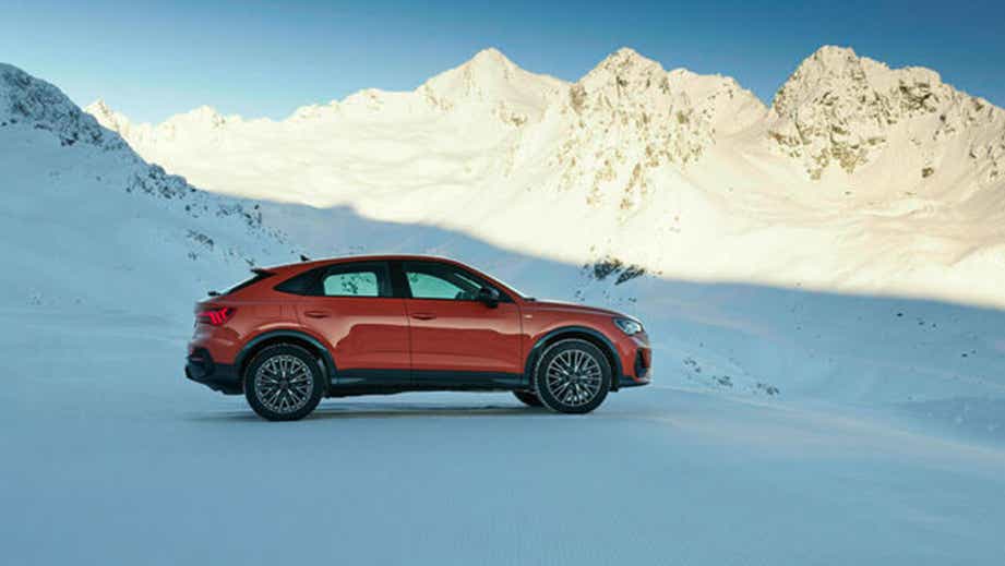 side view of an Audi Q3 Sportback in a snowy mountain setting