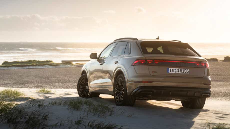 Rear three-quarter view of an Audi Q8 on a beach