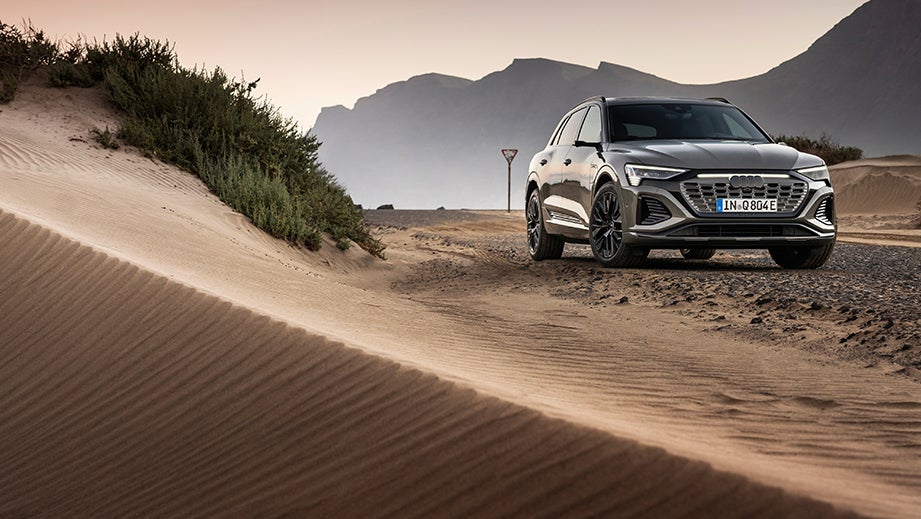 front view of a Chronos Grey Metallic Audi Q8 e-tron on a desert road