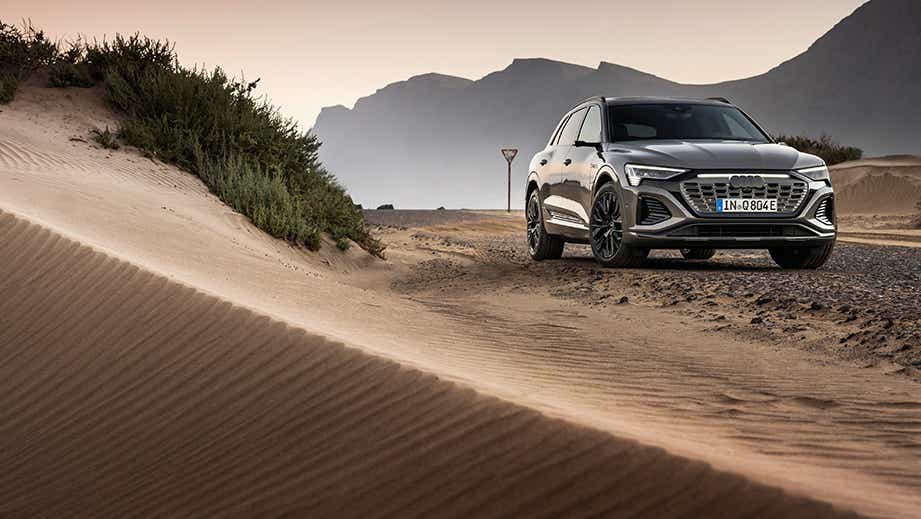 front view of a Chronos Grey Metallic Audi Q8 e-tron on a desert road