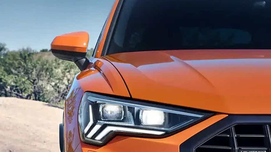 Front headlight close-up of a Pulse Orange Solid Audi Q3
