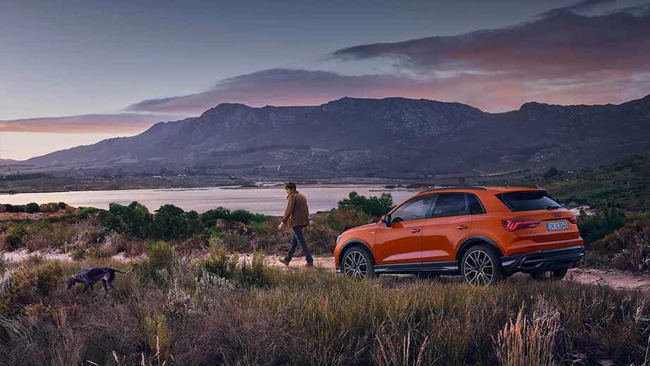 rear three-quarter of a Pulse Orange Solid Audi Q3