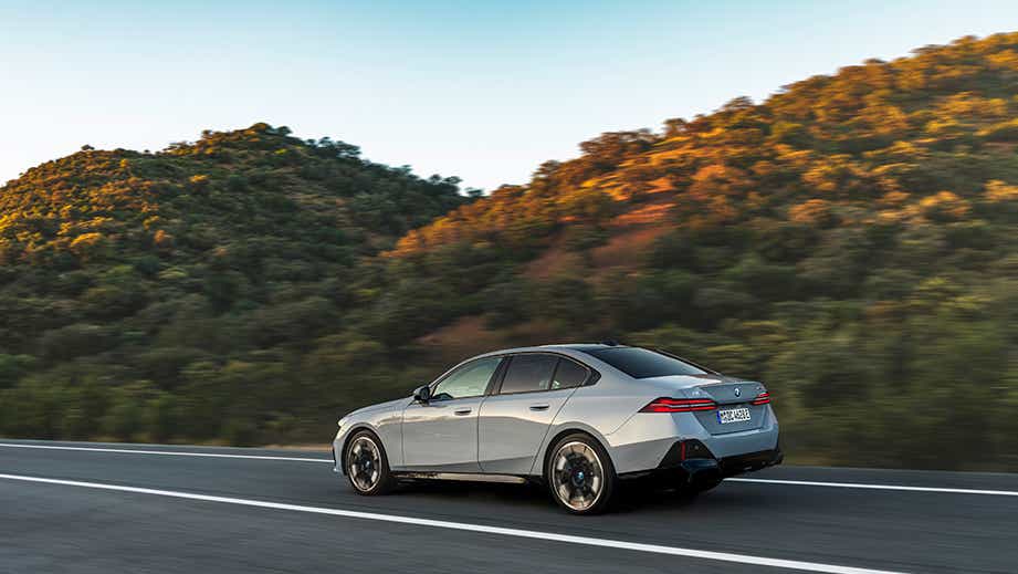 rear three-quarter of a Mineral White BMW 5 Series