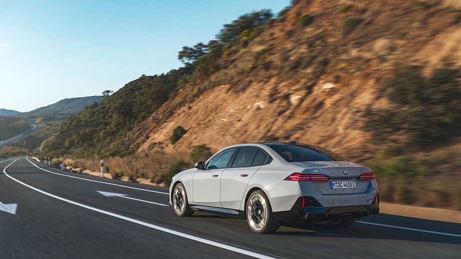 rear three-quarter view of a Mineral White BMW 5 Series