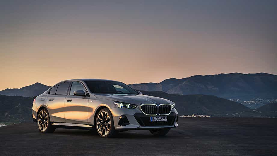 front three-quarter view of a Mineral White BMW 5 Series