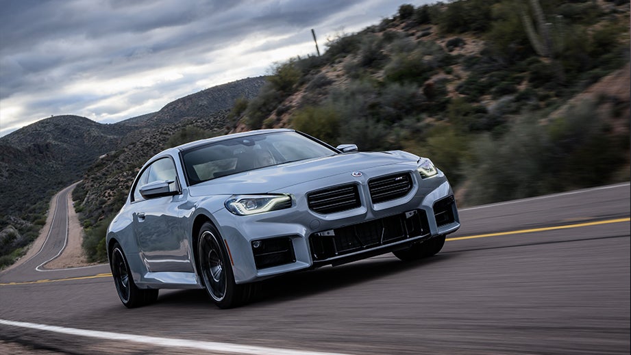front three-quarter view of a BMW M2 on a winding road