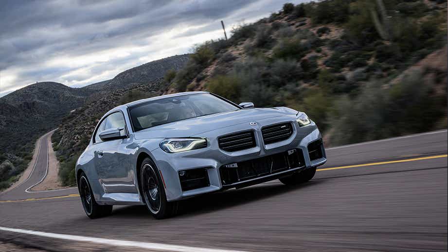 front three-quarter view of a BMW M2 on a winding road