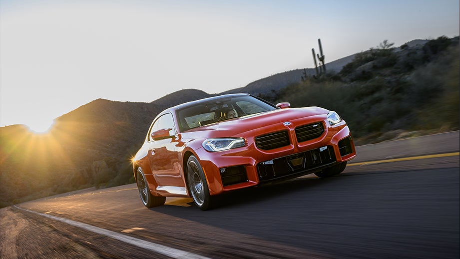 front three-quarter view of a BMW M2 on a desert road