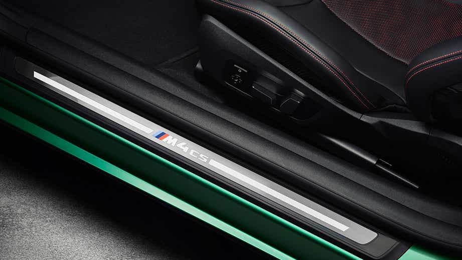 Interior door sill with M4 CS badge of a BMW M4 Competition