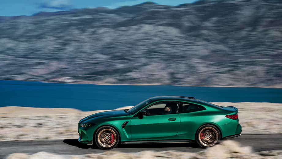 Profile view of a BMW M4 CS coupe driving outdoors