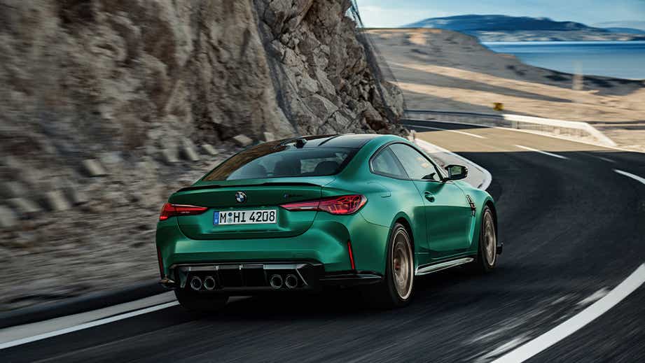 rear three-quarter view of a BMW M4 CS on a mountain road