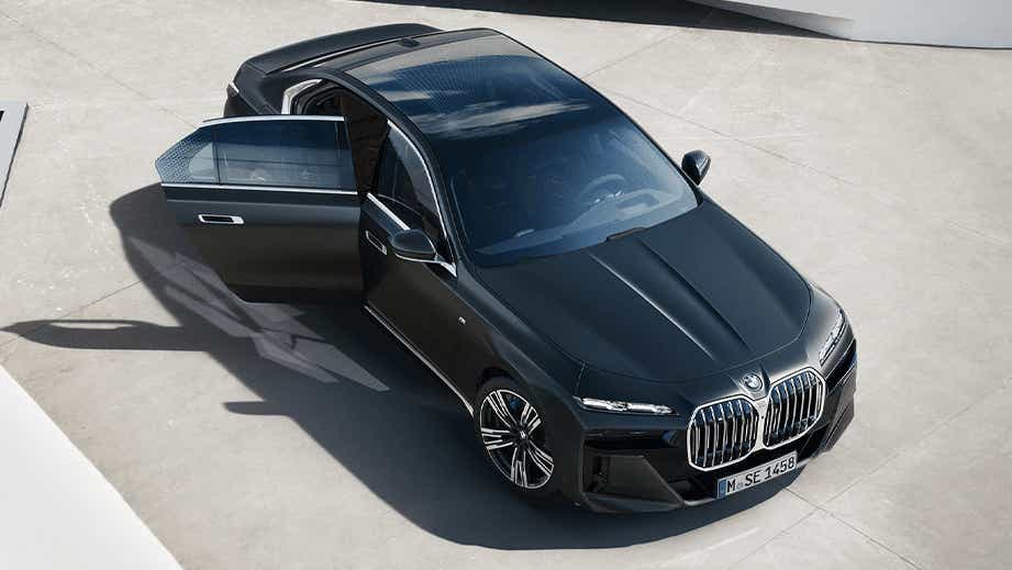 front three-quarter view of a Black Sapphire Metallic BMW 7 Series with driver door open