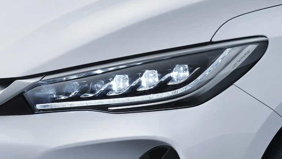 Headlight close-up of a Crystal White BYD eMAX 7