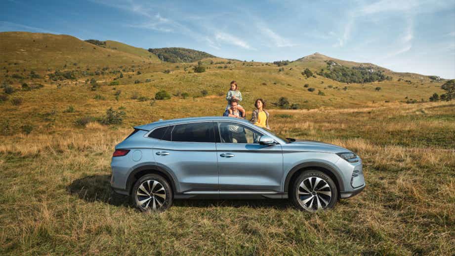 side view of a BYD Seal U SUV parked outdoors in a grassy field