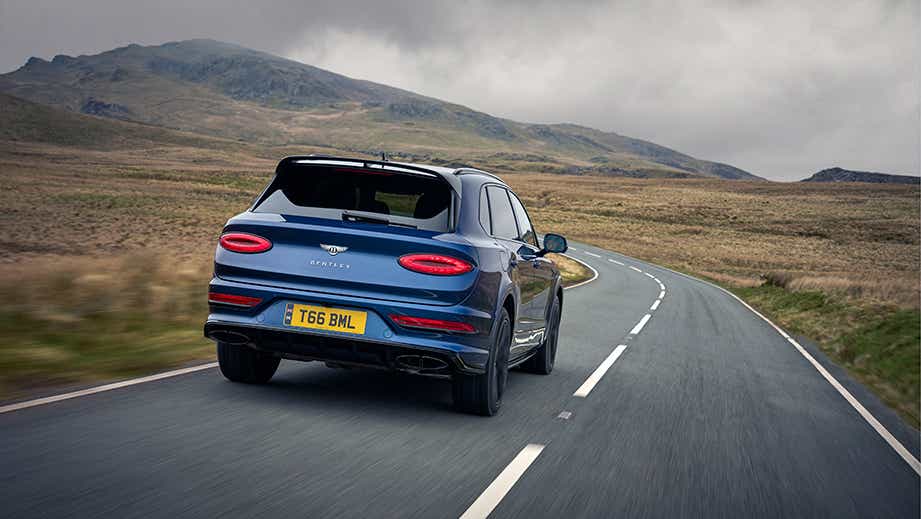 Rear view of a Bentley Bentayga driving on a winding road