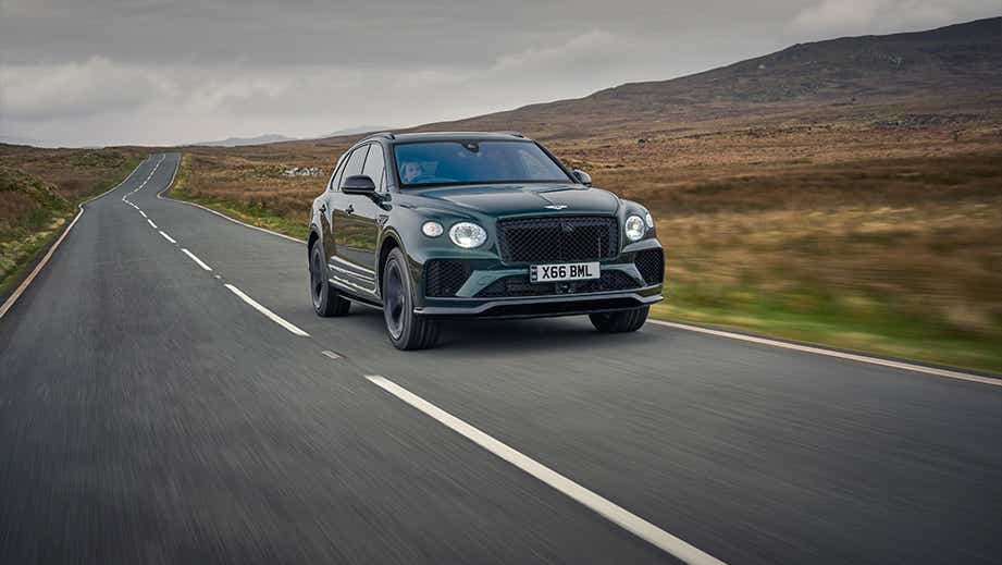 front view of a Bentley Bentayga driving on a country road