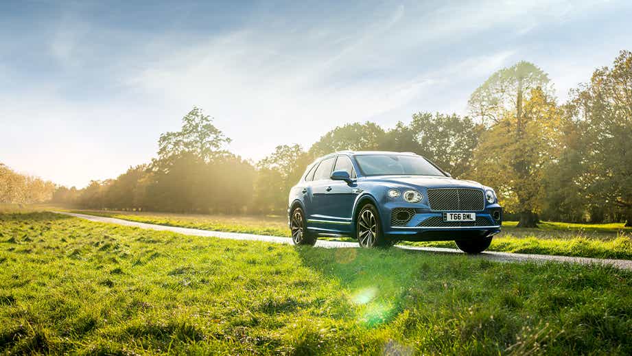 front three-quarter view of a Bentayga on a country road