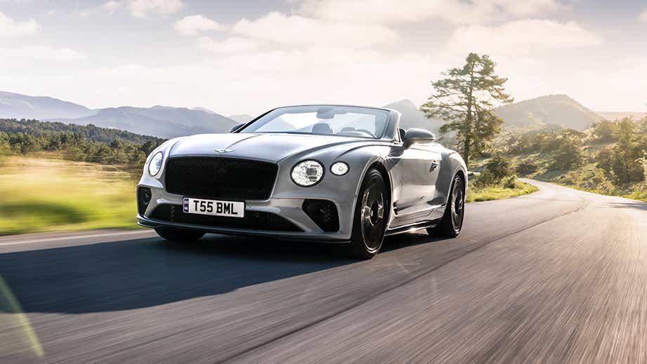 front three-quarter view of a Bentley Continental on a scenic road