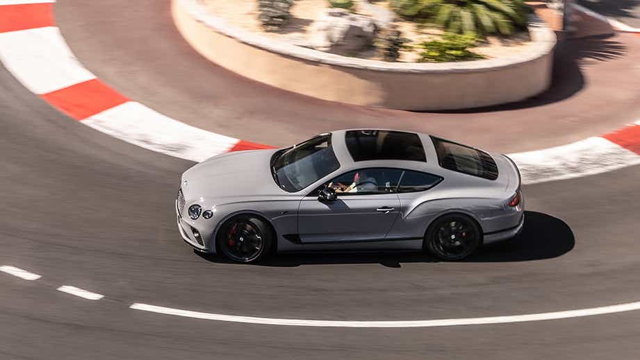 side view of a Bentley Continental coupe driving on a racetrack