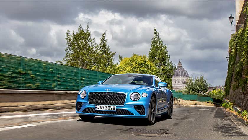 Front view of a Blue Crystal Bentley Continental driving on a city road