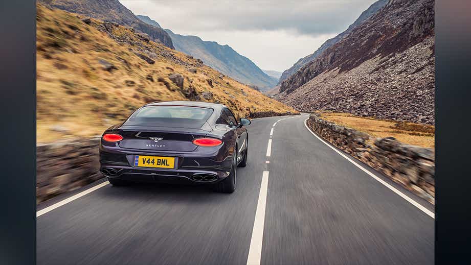 Rear view of a Bentley Continental driving on a mountain road