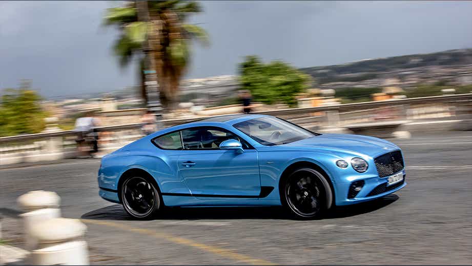 side view of a Bentley Continental coupe driving on a city street