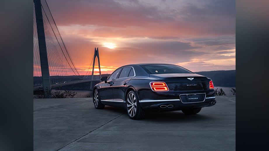 rear three-quarter view of a Bentley Flying Spur at sunset