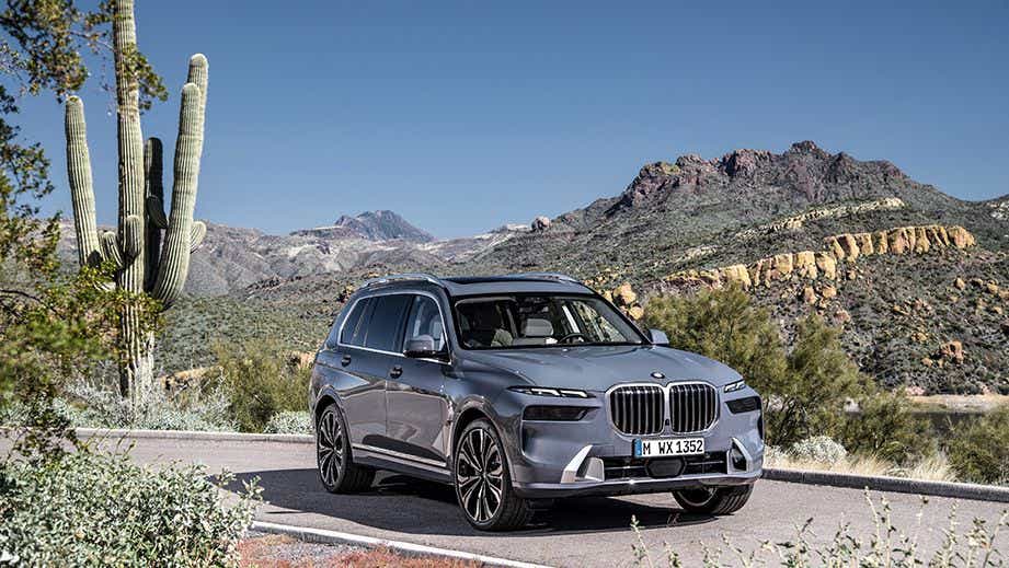 Front three-quarter view of a BMW X7 on a scenic mountain road