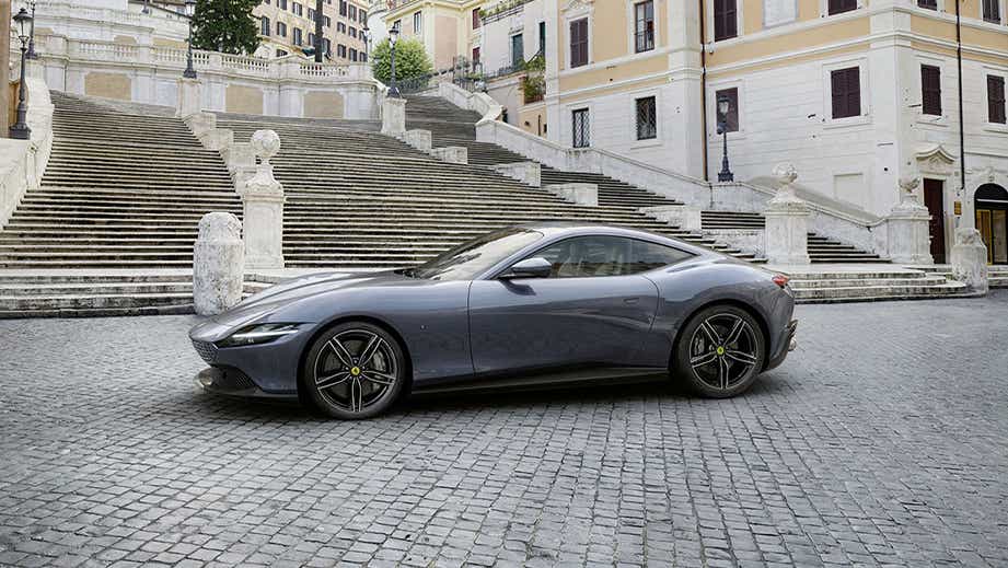 side view of a Ferrari Roma parked by historic stone steps