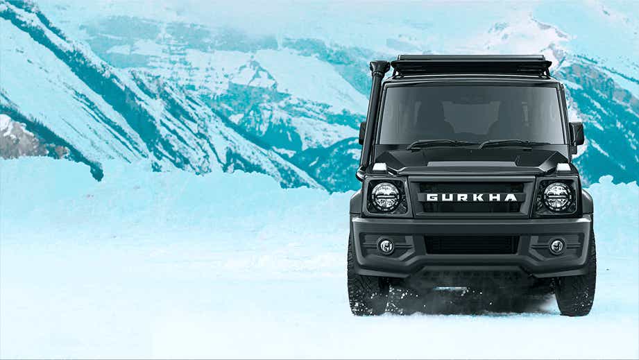 Front view of a Force Gurkha on snowy terrain with mountains in background