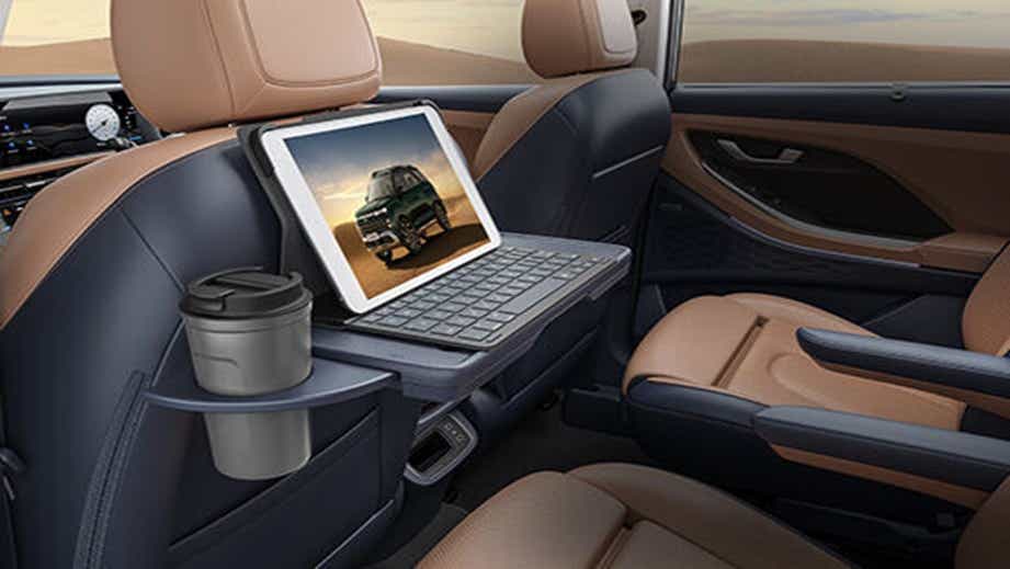Rear seat workspace setup in a Hyundai Alcazar with tray table and cup holder