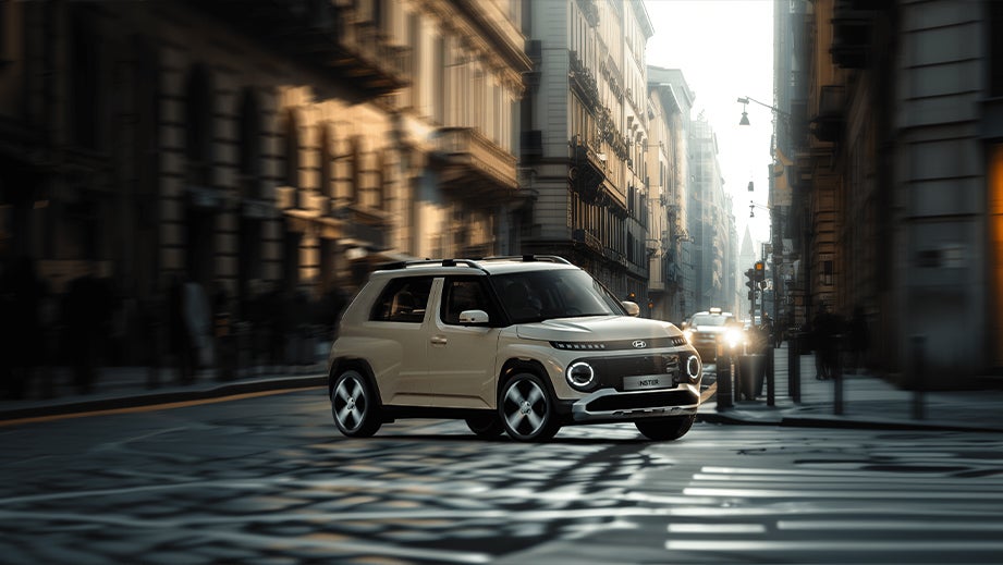 Front three-quarter view of a Hyundai Inster EV on a city street