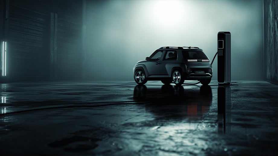 Rear three-quarter view of a Hyundai Inster EV at a charging station