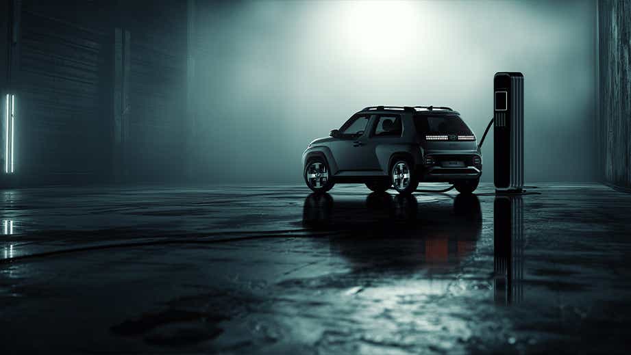 Rear three-quarter view of a Hyundai Inster EV at a charging station