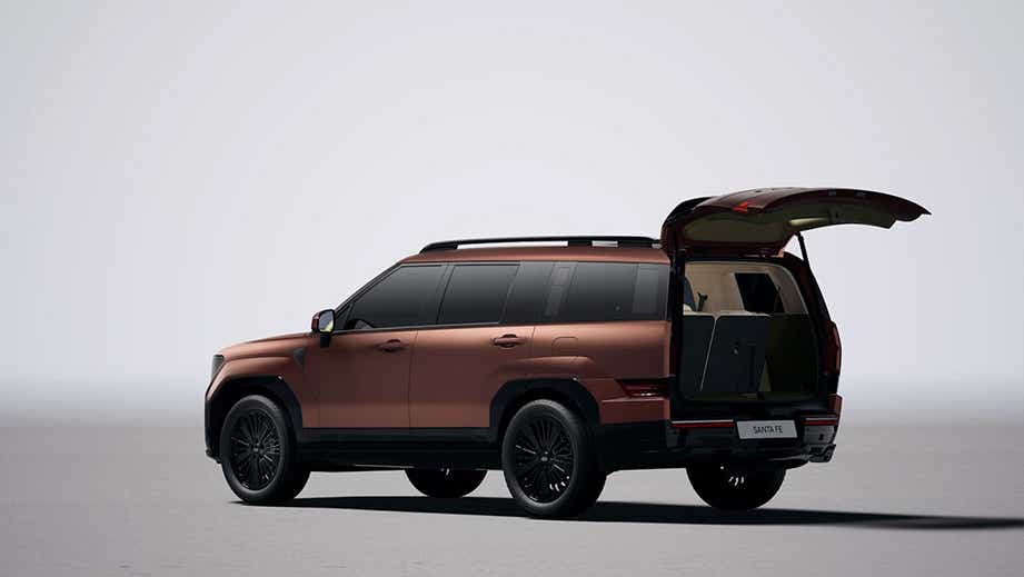 rear three-quarter view of a Earthy Brass Matte Hyundai New Santa Fe with open boot