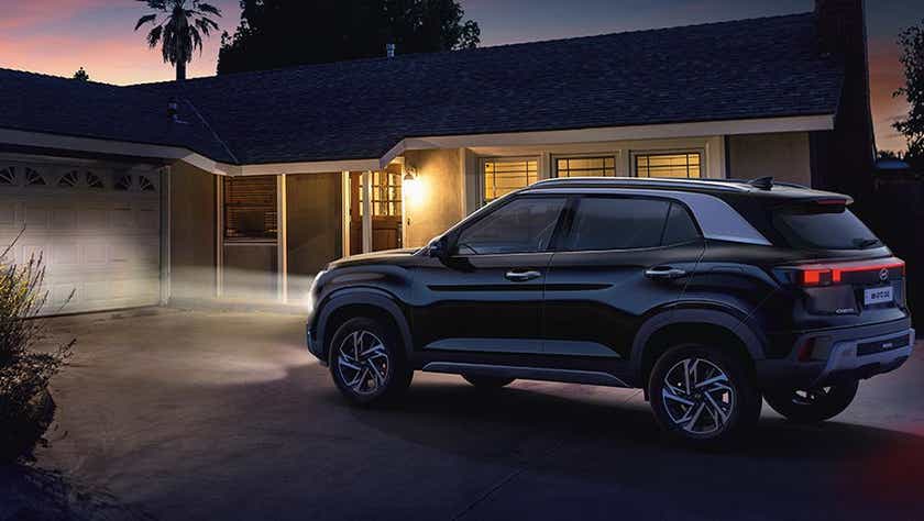 Side view of a Hyundai Creta parked in a driveway at night