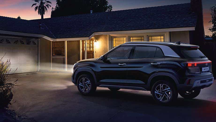 Side view of a Hyundai Creta parked in a driveway at night