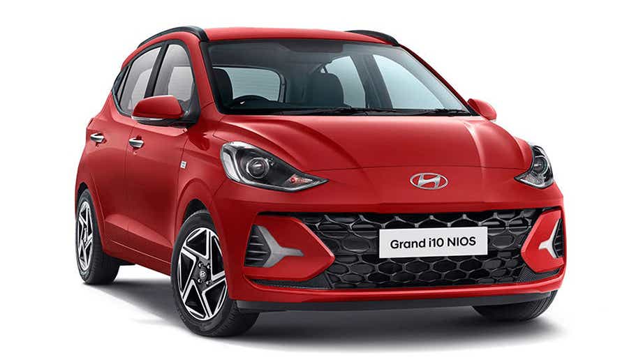 front three-quarter view of a Fiery Red Hyundai Grand i10 Nios