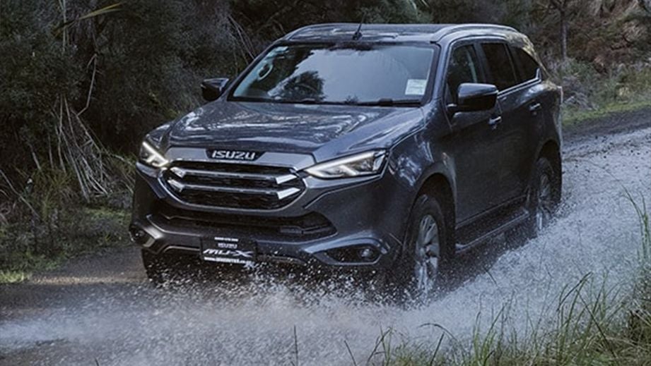 front view of a Isuzu MU-X driving through water