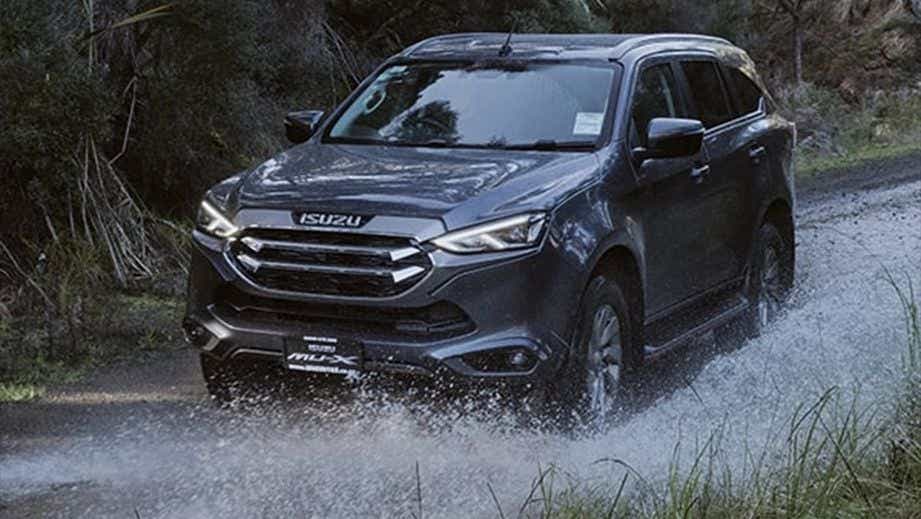 front view of a Isuzu MU-X driving through water