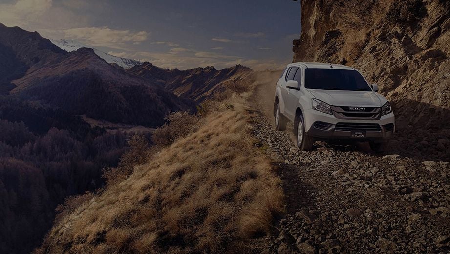 front view of an Isuzu MU-X driving on a mountain trail